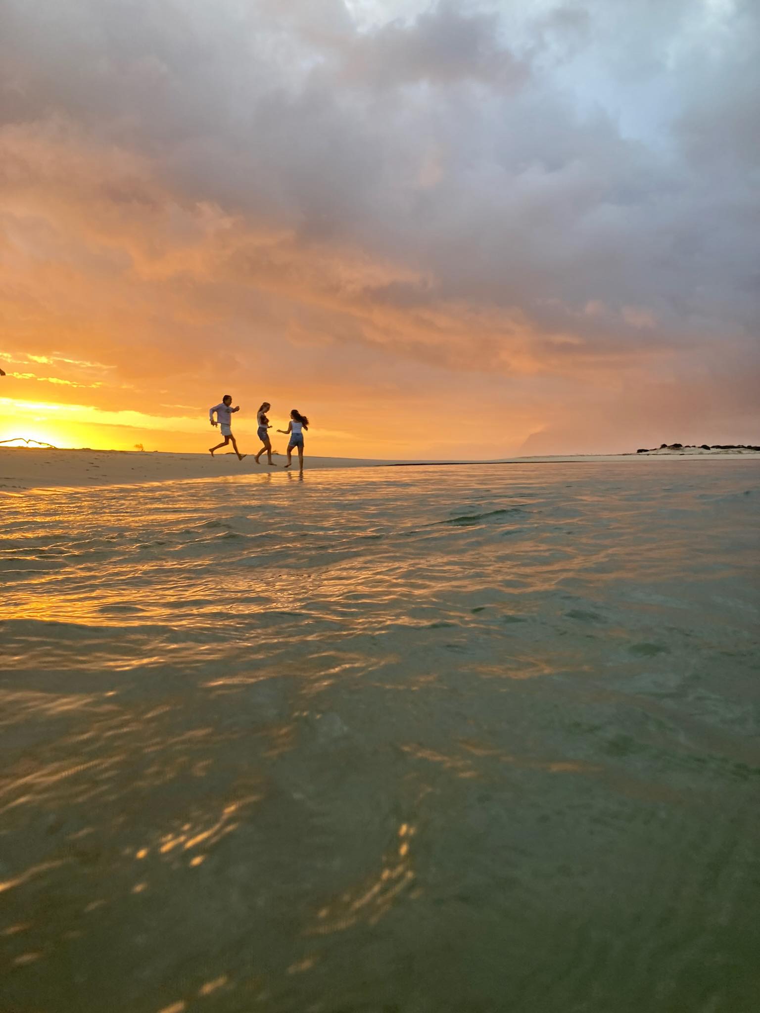 Children playing on a beach at sunset